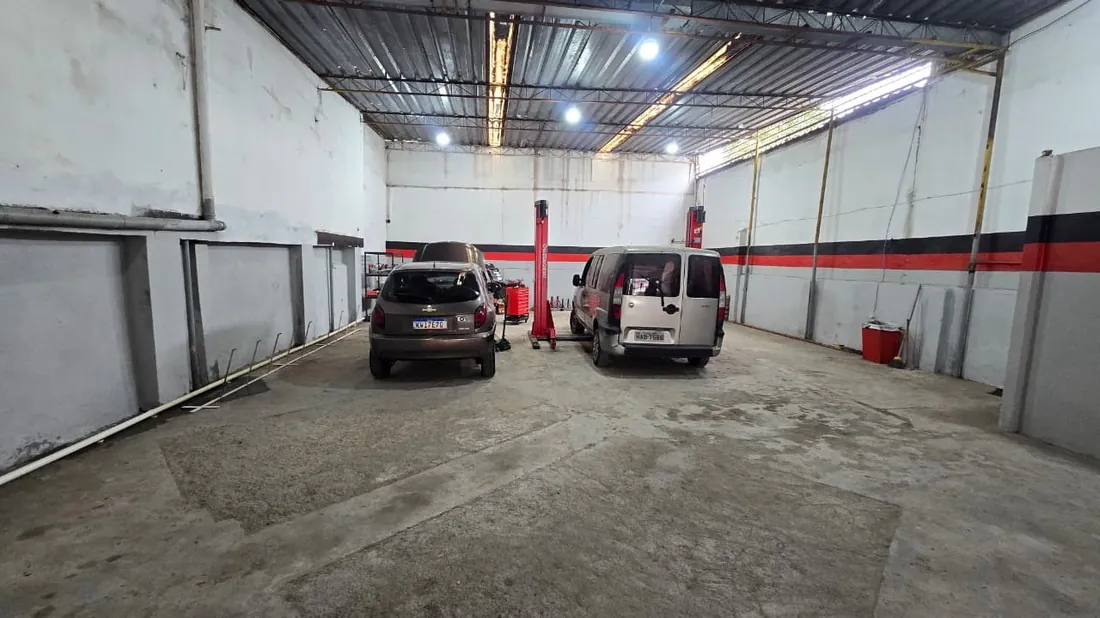 Interior amplo da oficina Top Car com carros e iluminação